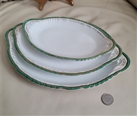 Preowned set of three antique Victoria Austria porcelain oval serving platters with decorative gold and green scalloped edges for elegant dining table centerpieces