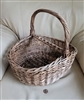 Large vintage handwoven willow wicker harvest basket showing thick bentwood overhead handle and dense weave structure