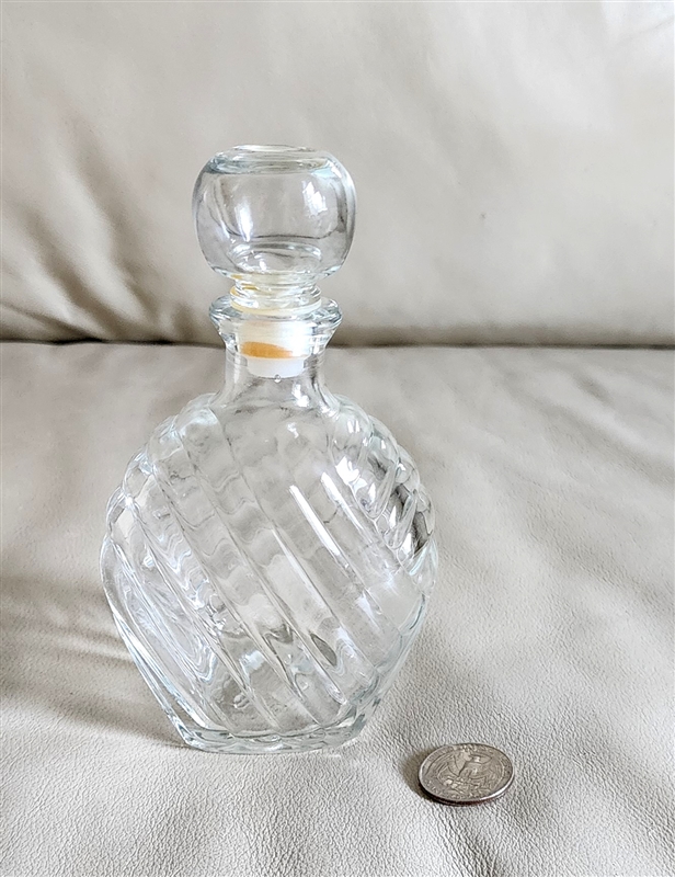 Clear vintage Italian glass cruet with optic swirl pattern and original stopper on a white background.