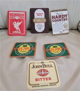 A diverse collection of vintage colorful beer mats in two different sizes featuring various brewery logos and branding
