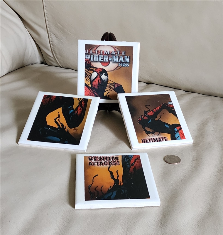 Four square ceramic coasters featuring colorful Ultimate Spider-Man and Venom comic book cover illustrations