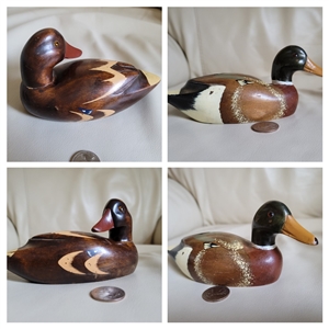 Pair of vintage-style hand painted and carved wooden duck decoys shown from multiple angles with reference coin
