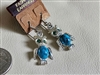 Vintage 1990s silver tone metal dangle owl earrings featuring blue marbled plastic body elements and green plastic eye accents