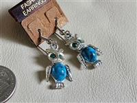 Vintage 1990s silver tone metal dangle owl earrings featuring blue marbled plastic body elements and green plastic eye accents