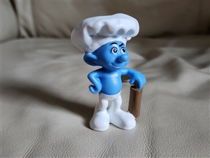 Front view of Blue Smurf Baker 2011 McDonalds Happy Meal toy wearing chef hat and holding rolling pin