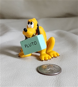 Front view of vintage Disney Pluto dog 2" PVC figure toy holding blue luggage in mouth