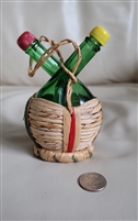Vintage Italian green glass cruet set with two bottles in a straw basket