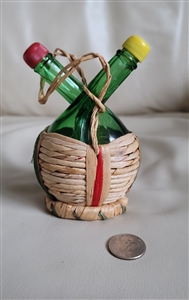 Vintage Italian green glass cruet set with two bottles in a straw basket