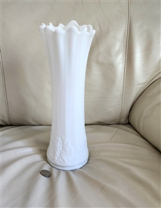 Preowned vintage Westmoreland milk glass 13 and half inch swung vase in Paneled Grape pattern with ruffled rim and embossed grape base next to a coin for scale