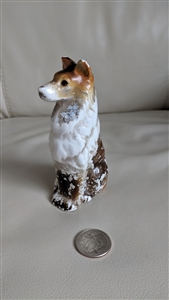 Vintage hand painted ceramic seated dog figurine with rust head and mottled dark brown body showing authentic paint wear
