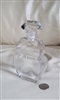 Mid-century vintage French clear glass perfume bottle featuring geometric flowing pattern and matching apothecary stopper