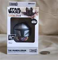 New old stock box displaying a silver Star Wars Mandalorian helmet mini bluetooth speaker next to a coin for size reference