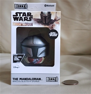 New old stock box displaying a silver Star Wars Mandalorian helmet mini bluetooth speaker next to a coin for size reference