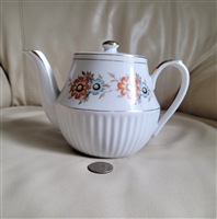 Vintage Chelsea Japan National Silver Company porcelain floral teapot shown with reference coin