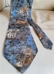 Pre-owned vintage Endangered Species 100% silk tie with detailed African wildlife illustrations including lions and elephants on a blue background.