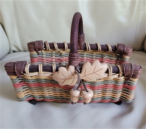 Handcrafted multi-color paper reed woven storage basket featuring soft fabric oak leaves and dangling wooden acorns