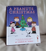 Vintage Peanuts book titled A Peanuts Christmas published in two thousand and two with some cover wear