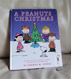 Vintage Peanuts book titled A Peanuts Christmas published in two thousand and two with some cover wear