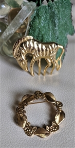Vintage 1980s gold tone zebra and floral wreath brooch set showing textured animal pin and leaf circle brooch front and back views