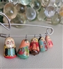 Folk art safety pin brooch jewelry with hand painted wooden nesting doll dangles