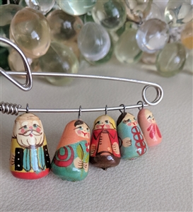 Folk art safety pin brooch jewelry with hand painted wooden nesting doll dangles
