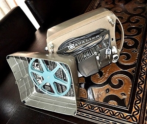 Cavalier De Luxe 8mm vintage movie projector with metal case and blue film reel