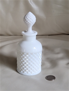 Westmoreland milk glass perfume bottle in Diamond Point pattern with matching stopper on vanity display