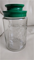 Pre-owned vintage embossed glass Tang kitchen storage jar with teal plastic screw-on lid for organization or collection