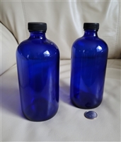 Pair of 1961 Swindell cobalt blue glass Boston Round apothecary bottles with black caps and 16 oz capacity
