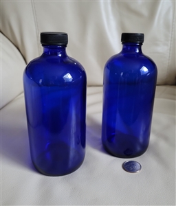 Pair of 1961 Swindell cobalt blue glass Boston Round apothecary bottles with black caps and 16 oz capacity