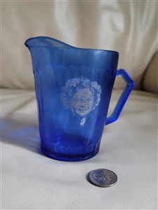 Hazel Atlas cobalt blue glass Shirley Temple cereal creamer pitcher with hexagonal honeycomb pattern and portrait from the 1930s