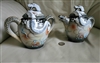 An antique Japanese moriage dragonware porcelain set includes a creamer and sugar bowl featuring a grey and white smoke background with hand painted 3 claw white dragons in high relief winding around the bodies