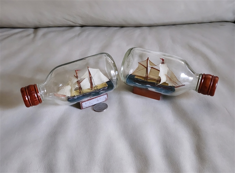 1970s pair of miniature ships in a bottle featuring handcrafted topsail schooners on wooden display stands for nautical decor.