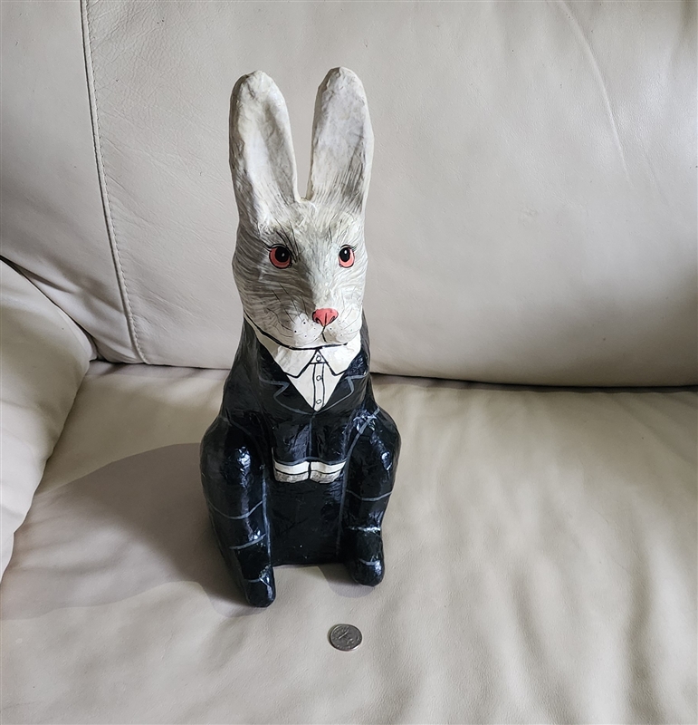 Large vintage paper mache seated rabbit in a suit shown from a front profile view