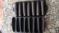 Top and back views of two vintage Wagner Ware cast iron corn shaped baking pans showing aged iron finish and manufacturer marks