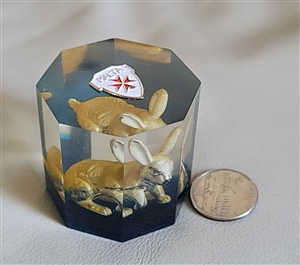 Hexagonal clear Lucite paperweight encasing a golden rabbit figurine with blue base layer and Maltese Cross emblem on top