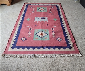 hand-woven Dhurrie rug made in India featuring a ceremonial elephant design with global folk art imagery and artisan origin texture