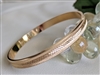 Vintage Monet gold tone bangle bracelet with etched diamond cut satin finish and polished edges