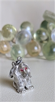 Vintage Monet silver tone sitting dog charm with red enamel eyes and satin finish