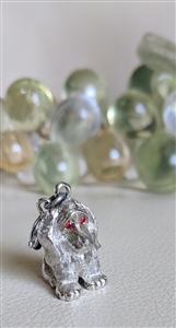 Vintage Monet silver tone sitting dog charm with red enamel eyes and satin finish