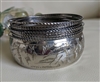 Eleven piece silver tone metal stacked bangle set featuring one thick etched floral bracelet and ten thin spacers