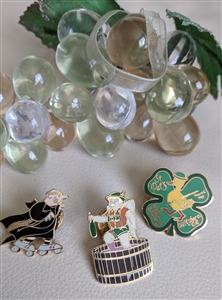 Set of three vintage metal enamel pins including a St Patricks Day duck a beer angel and a clergyman