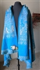 Handmade turquoise and beige wool shawl from India draped on a mannequin with reverse design and fringes.
