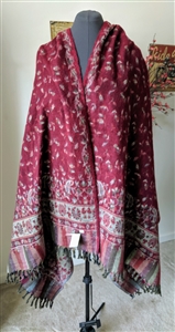 Handmade burgundy and red floral wool shawl from India with green accents and fringe detail.