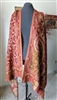 Handmade wool shawl with red floral and yellow geometric patterns from India draped on a mannequin.