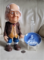 Vintage Benjamin Franklin plastic money bank next to a blue and white Enoch Wedgwood coaster from the 1970s