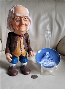 Vintage Benjamin Franklin plastic money bank next to a blue and white Enoch Wedgwood coaster from the 1970s