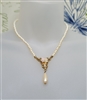 Vintage white plastic faux pearl necklace with gold tone filigree floral pendant and teardrop drop