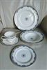 Five piece vintage 1986 Royal Doulton Albany bone china place setting with blue and yellow floral borders and gold trim on a cream ground