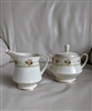 Noritake Normandy pattern cream porcelain footed creamer and lidded sugar bowl set with fruit floral motifs from the 1970s